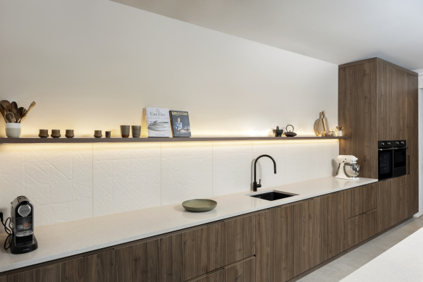 Moderne keuken met wit composiet tablet Caesarstone clamshell. Donker houtkleurige greeploze fronten.